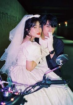 a man and woman dressed in wedding attire on a motorcycle