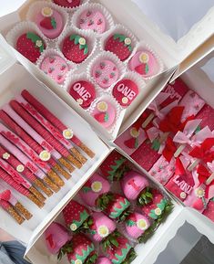 strawberry shaped cupcakes and strawberries are displayed in boxes