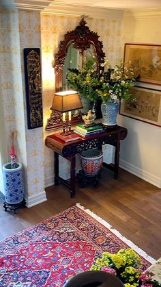 a living room with a rug, mirror and vases on the table in front of it