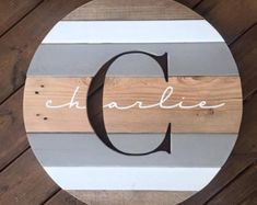 a wooden sign with the word charlotte painted on it's side, sitting on top of a wood floor