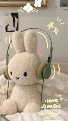 a white stuffed animal with headphones on it's ears sitting on a bed