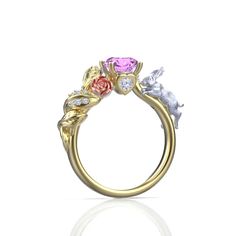 a gold ring with three different colored stones