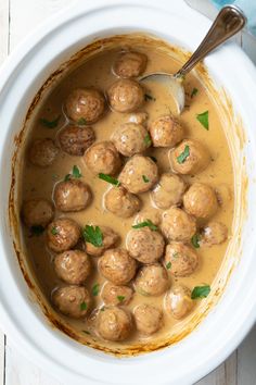 a white bowl filled with meatballs and gravy