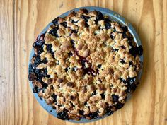 a blueberry pie sitting on top of a wooden table