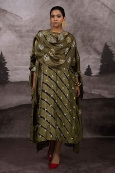 Olive green batwing sleeves kaftan style cape with all over flora cluster embroidery using metallic thread and pitta highlights. Paired with a round keyhole neckline kurta with all over leheriya wave pattern and Bandhani inspired motif pitta embroidery. - Aza Fashions Festive Long Sleeve Kaftan With Sheer Dupatta, Festive Silk Outerwear With Traditional Drape, Festive Traditional Drape Outerwear With Dupatta, Festive Outerwear With Traditional Drape Dupatta, Festive Outerwear With Traditional Drape And Dupatta, Festive Outerwear With Dupatta For Eid, Festive Eid Outerwear With Dupatta, Festive Designer Chanderi Outerwear, Festive Chanderi Outerwear With Resham Embroidery