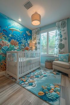 a baby's room decorated in blue and white with an ocean theme on the wall