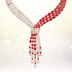 This exquisite set, draped in radiant yellow gold, exudes a timeless charm, while the sparkling Diamondeau®, flawless simulated diamond, adds a touch of sophistication and glamour. At the heart of this ensemble is a necklace that elegantly flows around the neck, reminiscent of a graceful tie, yet imbued with a sense of femininity and grace. The red and white gems create a mesmerizing contrast that captivates the eye and commands attention. Completing the set are the matching earrings. Each earri Elegant Cubic Zirconia Jewelry Sets For Valentine's Day, Elegant Rhinestone Jewelry Sets For Party, Elegant Diamond White Jewelry Sets For Parties, Elegant Jewelry Sets For Valentine's Day Formal, Elegant Diamond White Crystal Jewelry Sets, Elegant Jewelry Sets For Valentine's Day Anniversary, Elegant Jewelry Sets For Anniversary On Valentine's Day, Glamorous Diamond Jewelry For Celebration, Glamorous Formal Necklaces With Elegant Design