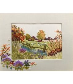 a cross stitch picture with sheep grazing in the field next to a fence and flowers