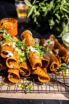 some food that is sitting on a cooling rack with sauces and herbs in the background