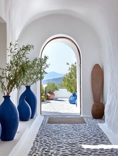 three blue vases sitting on top of a counter next to an arch in a building