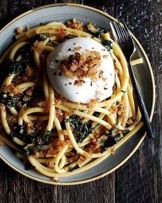 a bowl filled with pasta and topped with cream