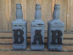 three bottles with the word bar painted on them