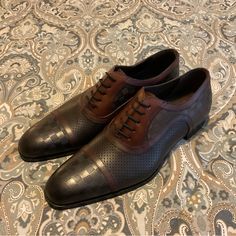 Brand New, New Worn, No Defects. Beautiful Style Oxfords, Made In Spain. Sold Out And Hard To Find Style And Color. Mezlan Checkerboard Leather Oxfords. Mens Sz 9 Medium. Official Color Is Black Burgundy But Is More Like Copper Black Brown. No Bo. Product Details On Last Photo. Please Check Your Sizing Accordingly To The Brand. Make Offers!! Brown Leather Cap Toe Shoes With Perforated Toe Box, Brown Leather Oxfords With Perforated Toe Box, Brown Dress Shoes With Perforated Toe For Business Casual, Brown Business Casual Dress Shoes With Perforated Toe, Brown Dress Shoes With Goodyear Welt Construction, Designer Brown Oxfords With Brogue Detailing, Brown Leather Shoes With Perforated Toe For Business Casual, Luxury Brown Oxfords, Masculine Brown Calf Leather Dress Shoes