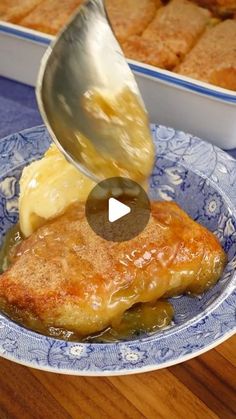 someone is pouring sauce on some food in a blue and white bowl with breaded potatoes