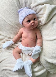 a baby wearing a diaper laying on top of a blanket