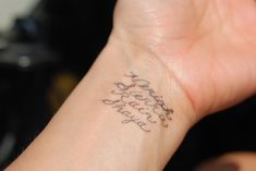 a woman's wrist tattoo with the words happy birthday written in cursive writing