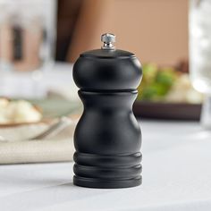 a black pepper mill sitting on top of a table