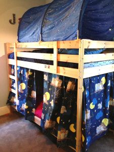 there is a bunk bed with blue sheets on the top and bottom beds below it