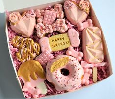 a pink box filled with lots of different types of donuts and other pastries