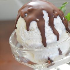 an ice cream sundae with chocolate drizzled on top in a glass bowl