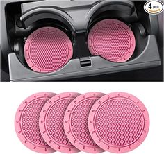 four pink round speakers in the center of a car