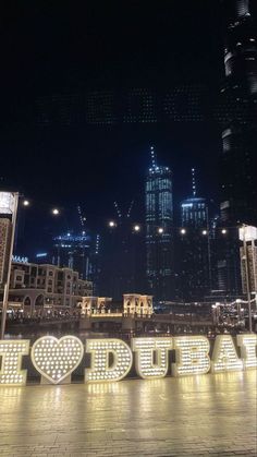 the word utopia is lit up in front of some tall buildings