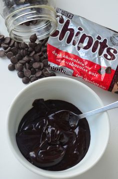 a bowl of chocolate pudding next to a bag of chips