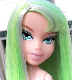 a doll with green hair and blue eyes is looking at the camera while standing in front of a window