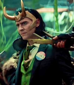 a man dressed as loki with horns on his head and holding an arrow in one hand