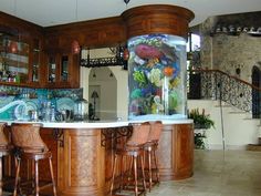 a fish tank sitting on top of a counter next to stools in a kitchen