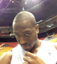 a man in a white jersey holding a basketball ball and looking at the camera with an excited look on his face