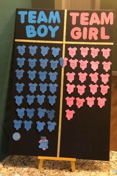 a black board with pink and blue clothes on it that says team boy and team girl