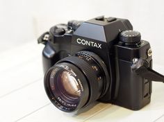 a black camera sitting on top of a white table