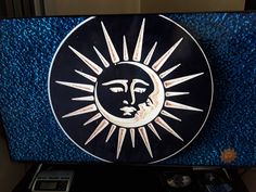 the sun and moon symbol is on top of a blue glass paneled television screen