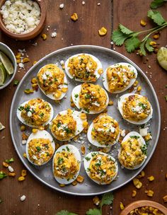 an overhead view of deviled eggs on a plate with corn and cilantro