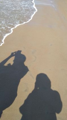 a shadow of a person standing on the beach