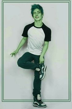 a young man with green hair is posing for a photo in front of a white background