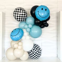 balloons are arranged in the shape of smiley faces and checkerboard wallpapers