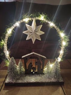 a lighted nativity scene with a star above it