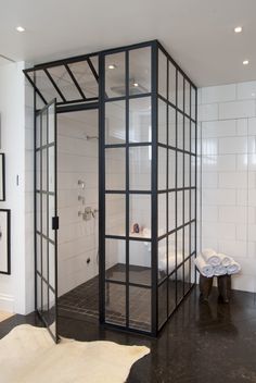 an open shower stall in a bathroom with black and white tile on the floor,