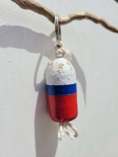 a red, white and blue object hanging from a rope