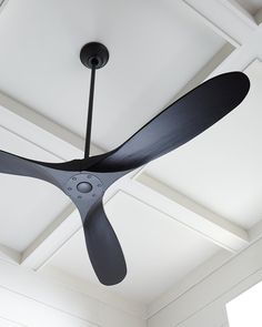 a ceiling fan that is hanging from the ceiling in a room with white walls and ceilings