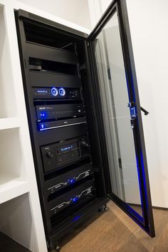 an open black and blue computer case in a white room with shelves on both sides