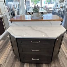 a kitchen island with marble counter tops and drawers