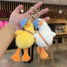 two small stuffed animals are being held by someone's hand in front of a bar