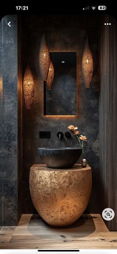 the bathroom is decorated in black and gold tones with modern fixtures, including an oval sink