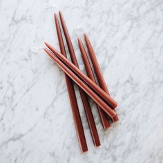 four red straws on a marble surface