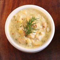 a white bowl filled with soup on top of a wooden table