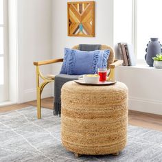 a living room with a chair, ottoman and coffee table