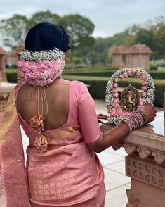 a woman wearing a pink sari and head piece